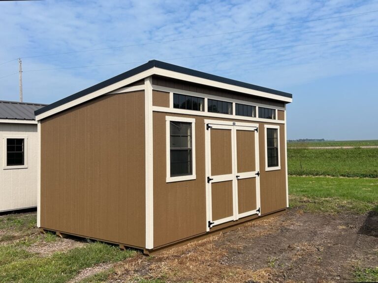 10x16 Studio Shed with brown painted siding, cream trim, and black steel metal roofing for sale near Vermillion, SD