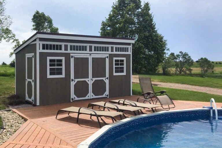 Pool side studio shed with white trim on deck with chairs