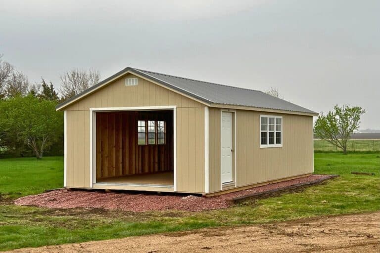 View of outside of 13-year-old garage before interior modification on gravel pad with beige walls and white door