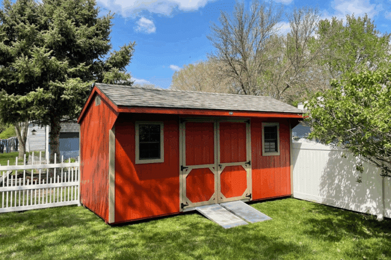 Storage shed with red swing doors.
